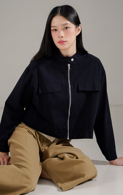 Averie Jacket Navy dari This Is April, jaket lengan panjang wanita warna biru navy dengan resleting depan, kerah tinggi (high-neck), dan detail saku dada.