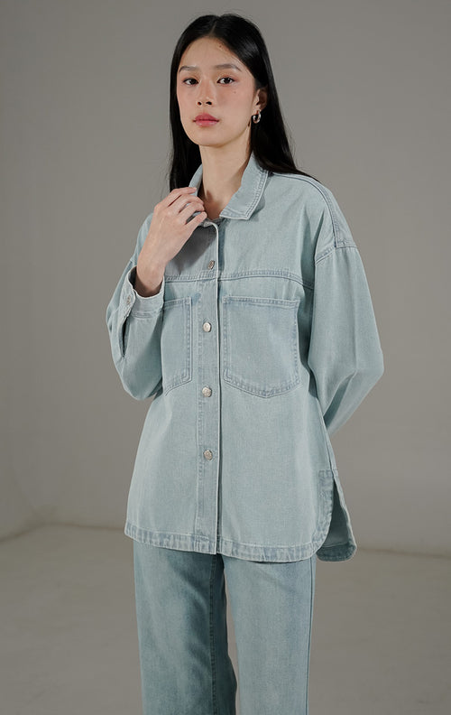  Beatrix Top Light Denim dari This Is April, kemeja denim wanita warna biru muda dengan dua saku dada aktif dan kancing metal perak.