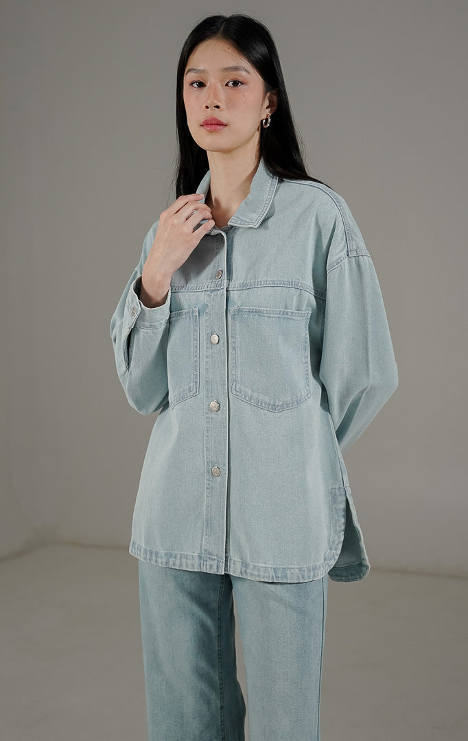  Beatrix Top Light Denim dari This Is April, kemeja denim wanita warna biru muda dengan dua saku dada aktif dan kancing metal perak.