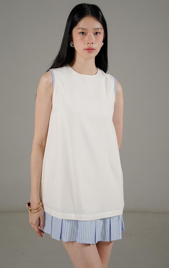 Tampilan belakang This Is April Belle Dress White, dress tanpa lengan minimalis warna putih dengan detail resleting dan lis garis-garis biru.