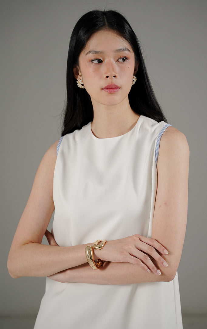 Tampilan belakang This Is April Belle Dress White, dress tanpa lengan minimalis warna putih dengan detail resleting dan lis garis-garis biru.