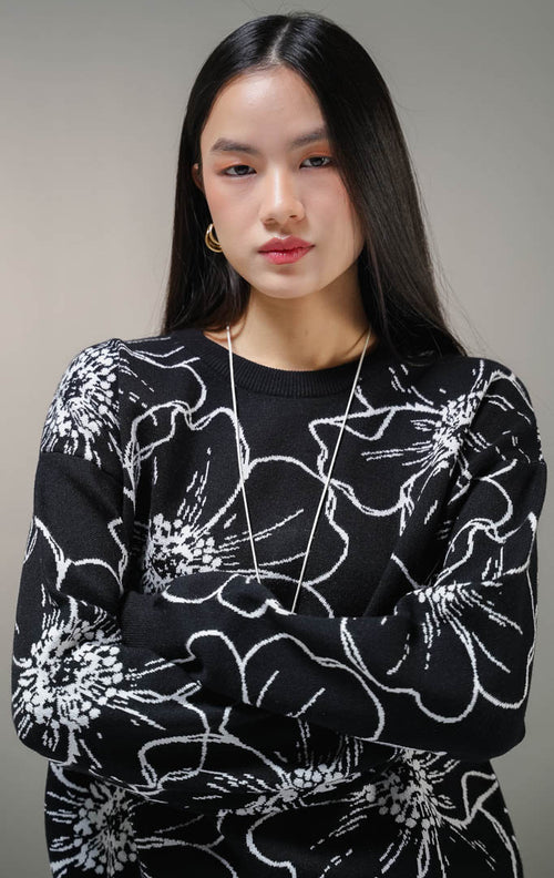 Atasan sweater rajut lengan panjang wanita This Is April Bowelle Sweater warna hitam, model kerah bulat crewneck dengan motif outline bunga besar warna putih di seluruh pakaian. 
