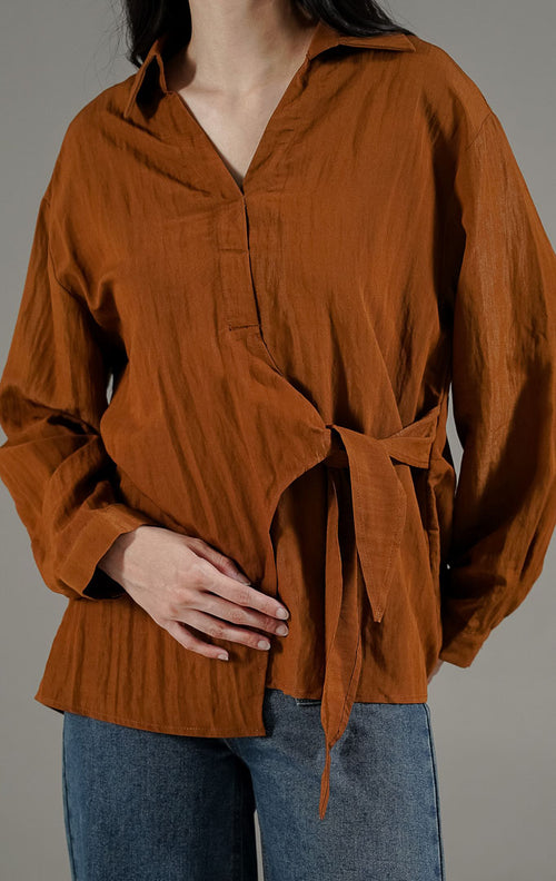 Bryanna Top Dark Brown dari This Is April, blus lengan panjang wanita warna cokelat tua dengan kerah V-neck dan detail tali pengikat di pinggang.