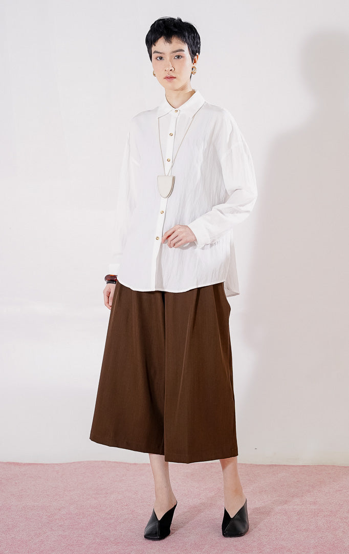 Kemeja wanita lengan panjang Caelia Top dari This Is April berwarna putih bersih dengan detail kancing depan, berbahan ringan, 
