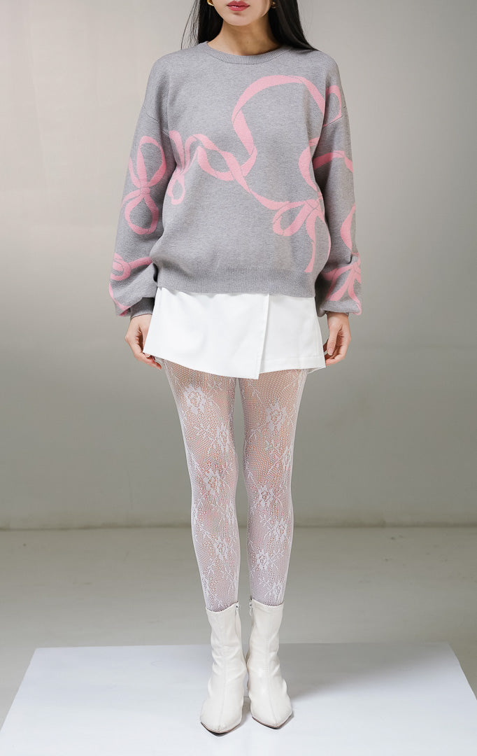 Atasan sweater rajut lengan panjang wanita This Is April Callie Sweater warna abu-abu (grey), model kerah bulat dengan detail motif grafis jalinan pita warna merah muda (pink) di bagian depan dan lengan. 