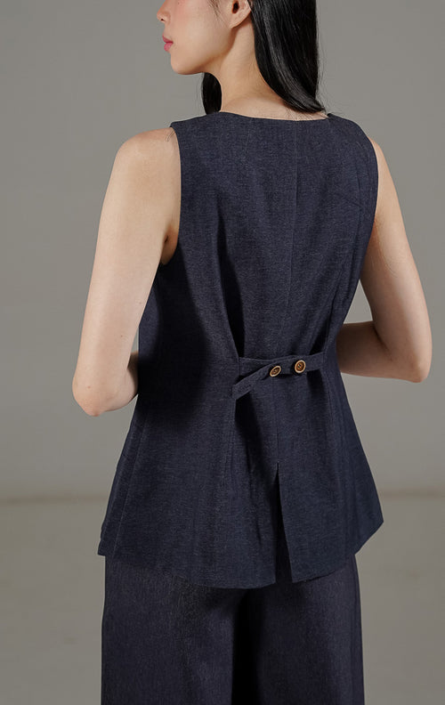 Camille Vest Navy dari This Is April, rompi tanpa lengan wanita warna biru navy dengan detail kancing depan dan tali pinggang yang bisa disesuaikan.
