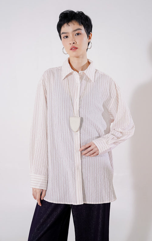 Kemeja wanita lengan panjang Carmela Top berpotongan oversize dari This Is April berwarna pink peach pucat dengan motif garis vertikal halus, berbahan ringan menerawang dengan kancing depan, 