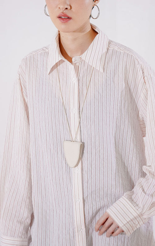 Kemeja wanita lengan panjang Carmela Top berpotongan oversize dari This Is April berwarna pink peach pucat dengan motif garis vertikal halus, berbahan ringan menerawang dengan kancing depan, 