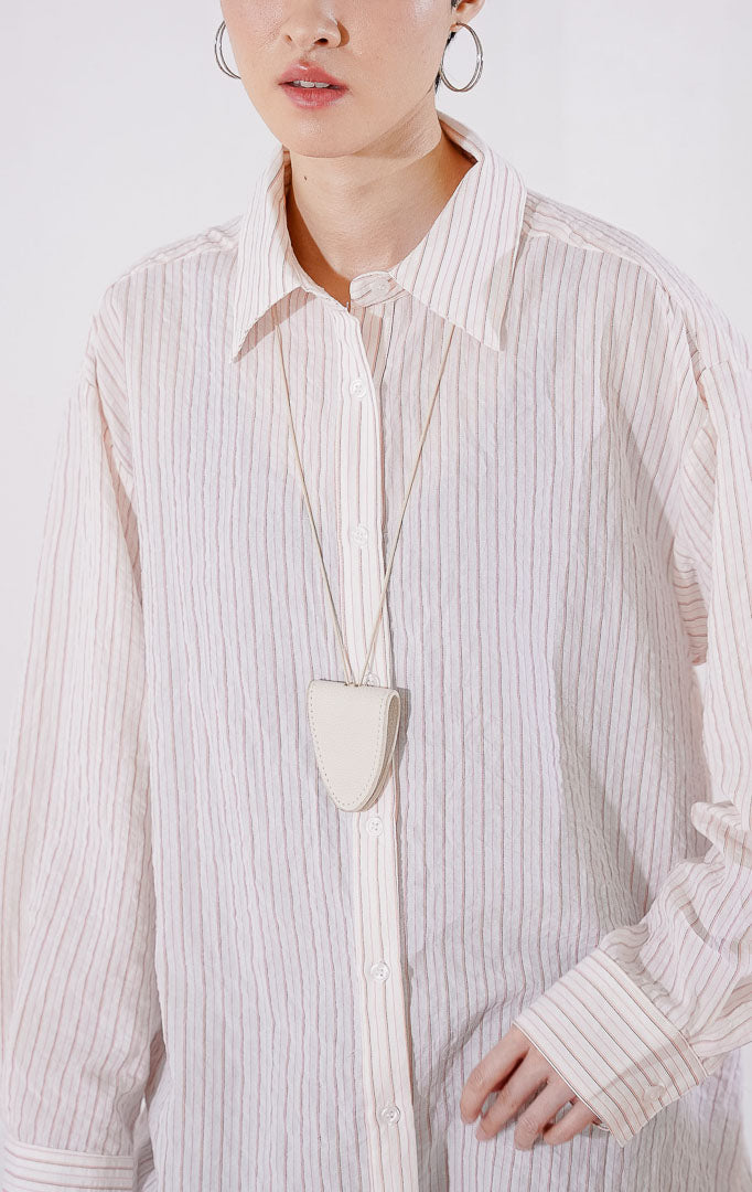 Kemeja wanita lengan panjang Carmela Top berpotongan oversize dari This Is April berwarna pink peach pucat dengan motif garis vertikal halus, berbahan ringan menerawang dengan kancing depan, 