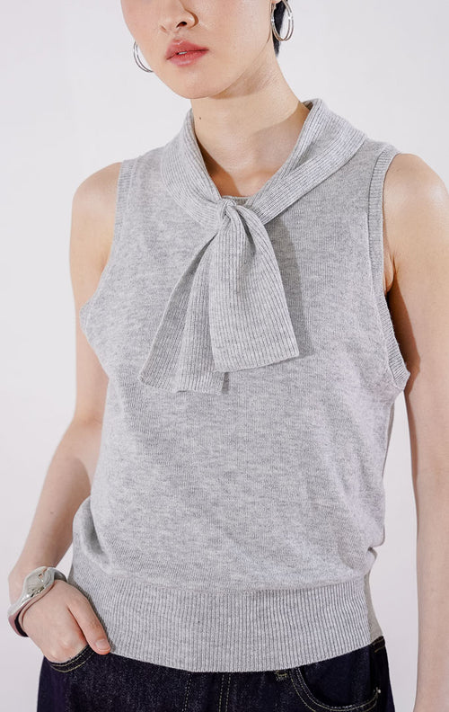 Tampak depan This Is April Claude Top warna abu-abu muda (light grey), atasan rajut tanpa lengan (sleeveless) dengan detail kerah pita dan kancing depan. 