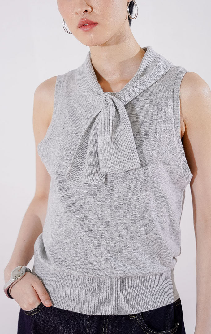 Tampak depan This Is April Claude Top warna abu-abu muda (light grey), atasan rajut tanpa lengan (sleeveless) dengan detail kerah pita dan kancing depan. 