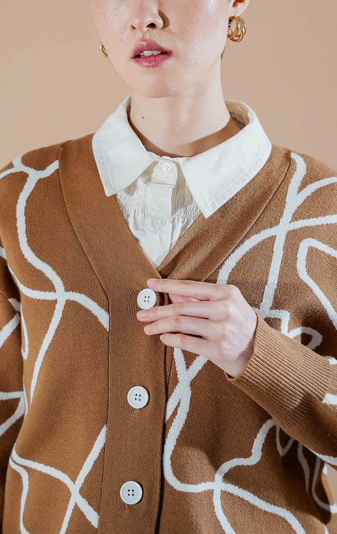 Coralina Cardigan Brown dari This Is April, cardigan rajut V-neck warna cokelat dengan motif garis abstrak putih dan kancing depan.