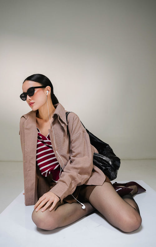 Kemeja lengan panjang wanita This Is April Cuthbert Top warna cokelat tua (brown) dengan kancing depan penuh senada dan detail kerah lebar beraksen layer lipat. 
