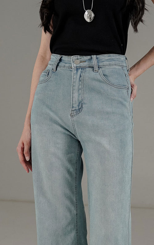 Celana panjang wanita Dolores Jeans warna biru muda (light denim) dari This Is April, dengan potongan wide-leg cut yang memberikan siluet kaki panjang.