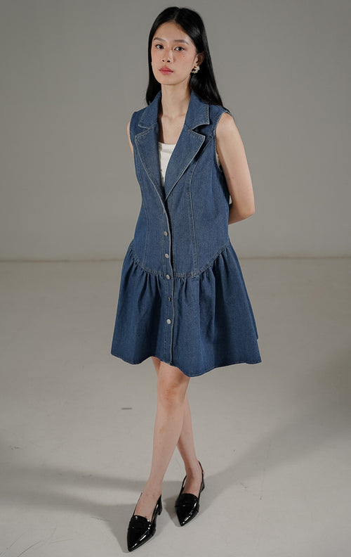 Eliette Dress Denim dari This Is April, gaun tanpa lengan kerah V dengan kancing depan dan siluet A-line warna biru denim.