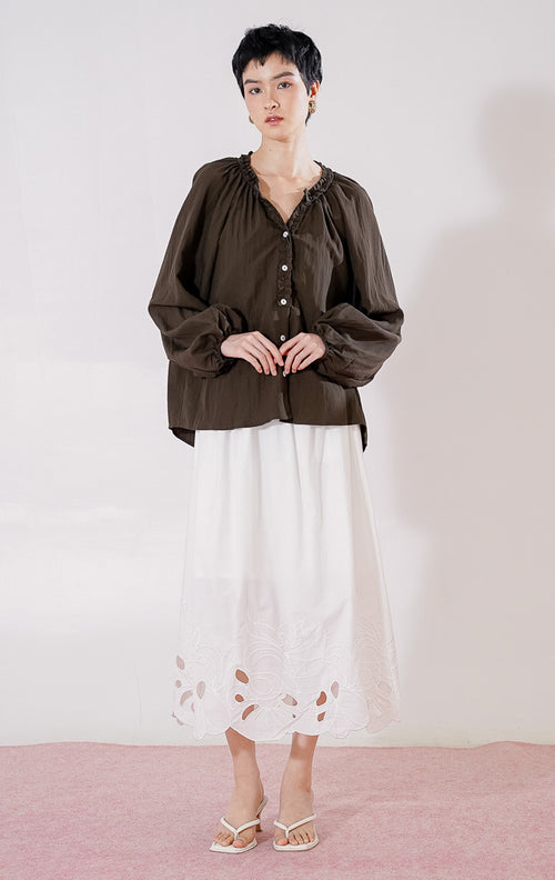 Blouse lengan panjang wanita This Is April Eloise Top warna dark brown berbahan katun, dengan kerah V-neck beraksen ruffle, kancing depan, dan ujung lengan karet. 
