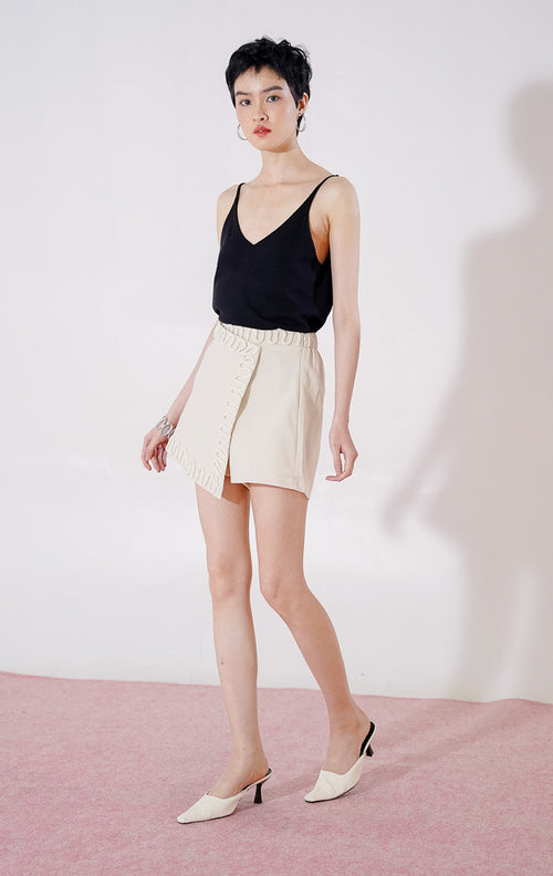 Rok celana wanita This Is April Elvio Skort warna ivory, dengan karet pinggang di bagian belakang, potongan depan asimetris bergaya wrap, dan detail lis tali bergelombang di sepanjang tepinya 