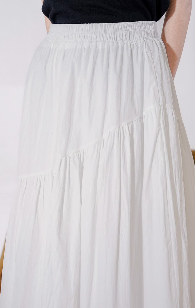 Rok panjang wanita This Is April Ember Skirt warna putih, berbahan ringan dan flowy, dengan full karet pinggang berkerut dan detail panel bersusun asimetris di bagian bawah