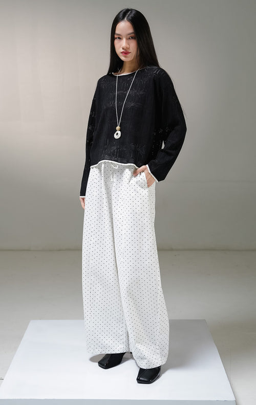Atasan sweater rajut lengan panjang wanita This Is April Evie Sweater warna hitam, model jaring mesh knit transparan dengan aksen list tipis warna putih tulang pada kerah bulat dan tepian bawah.