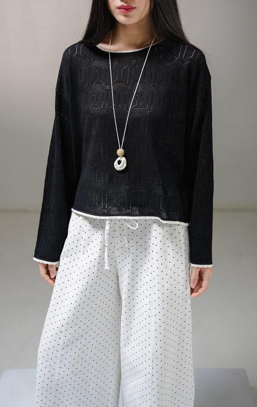 Atasan sweater rajut lengan panjang wanita This Is April Evie Sweater warna hitam, model jaring mesh knit transparan dengan aksen list tipis warna putih tulang pada kerah bulat dan tepian bawah.