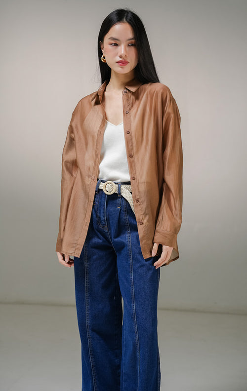 Kemeja lengan panjang wanita This Is April Favino Top warna cokelat, model oversized shirt dengan material kain sheer transparan halus yang menerawang dan detail kancing depan hidup.