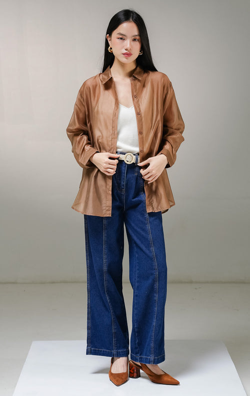 Kemeja lengan panjang wanita This Is April Favino Top warna cokelat, model oversized shirt dengan material kain sheer transparan halus yang menerawang dan detail kancing depan hidup.