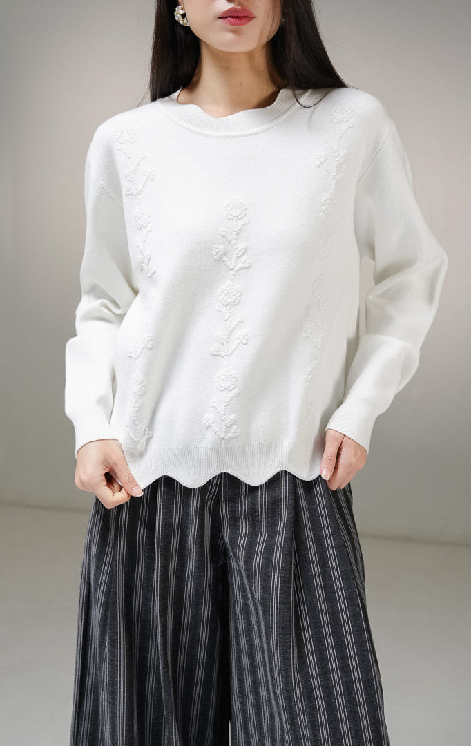 Atasan sweater rajut lengan panjang wanita This Is April Galina Sweater warna putih dengan detail tiga lajur motif bunga timbul (bertekstur) di bagian depan.