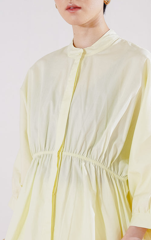 Atasan wanita This Is April Ginera Top warna kuning pastel, lengan panjang dengan detail karet pada bagian pinggang dan kerah shanghai minimalis