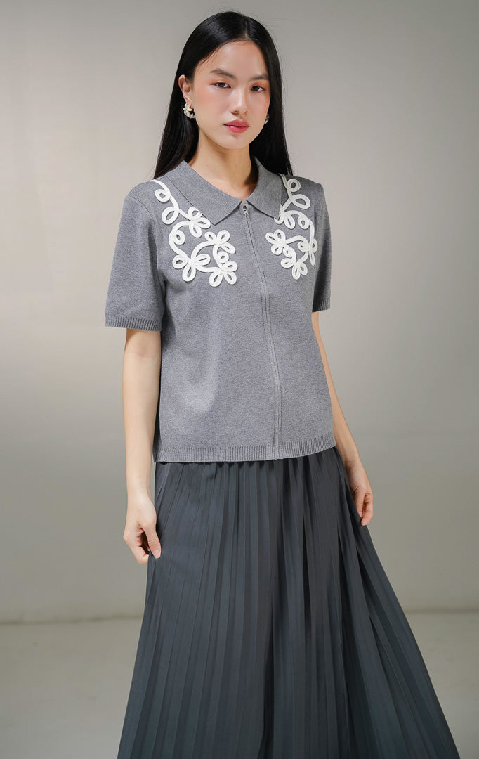 Atasan baju rajut wanita This Is April Gwynette Top warna abu-abu, lengan pendek berkerah dengan ritsleting depan penuh dan detail bordir motif tali putih di bagian dada.