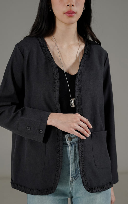 Jordane Cardigan Dark Grey dari This Is April, cardigan lengan panjang warna abu-abu tua dengan detail ruffle di tepian dan saku depan.