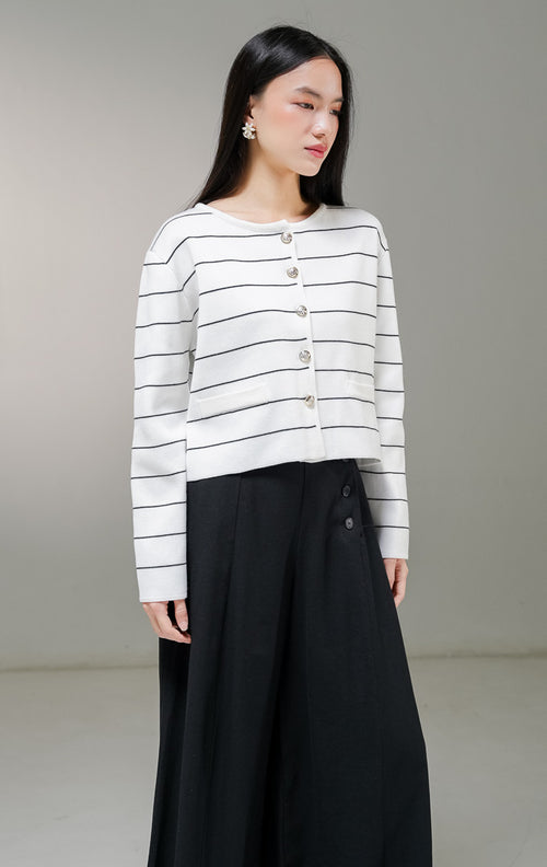 Kardigan rajut lengan panjang wanita This Is April Karleen Cardigan warna putih motif garis horisontal hitam, dengan kancing depan warna emas dan dua aksen kantong tiruan. 