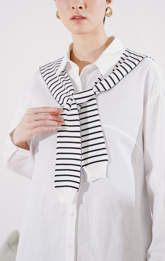 Kemeja wanita lengan panjang Krystal Top dari This Is April berwarna putih bersih berkerah klasik, dilengkapi dengan kancing depan dan aksen syal rajut motif garis hitam putih yang diikatkan di kerah 