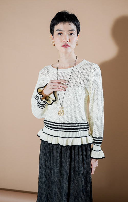 This Is April Laurent Cardigan Ivory, atasan rajut warna putih gading dengan detail ruffle dan aksen garis hitam di lengan dan ujung bawah.