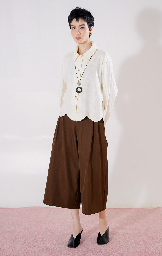 Kemeja lengan panjang wanita This Is April Layne Top warna ivory berbahan katun linen, berkerah klasik, dengan kancing depan dan detail bordir floral pada ujung bawah bergelombang