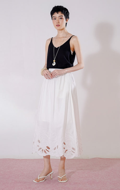 Rok panjang wanita This Is April Lilou Skirt warna putih, berpotongan longgar dengan full karet pinggang berkerut, dan detail bordir cut-out bermotif gelombang di sepanjang ujung bawah rok