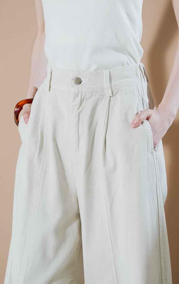 Lowyne Barrel Pants Ivory dari This Is April, celana panjang denim wanita warna putih gading dengan siluet barrel-leg yang melengkung modern dan kancing depan.