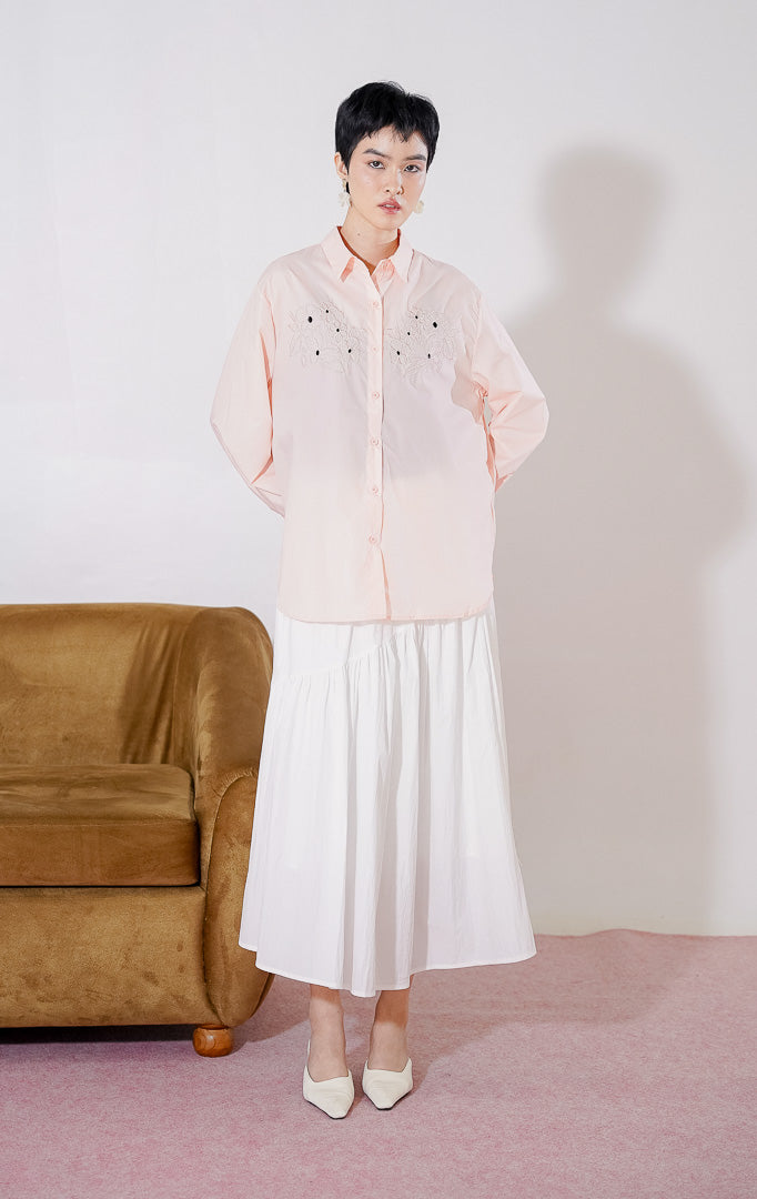 Kemeja wanita This Is April Oakley Top warna Pink Peach dengan lengan panjang, kerah klasik, kancing depan, dan aksen bordir bunga pada bagian dada. 