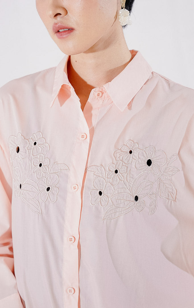 Kemeja wanita This Is April Oakley Top warna Pink Peach dengan lengan panjang, kerah klasik, kancing depan, dan aksen bordir bunga pada bagian dada. 