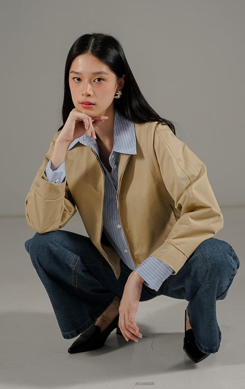  Othriel Jacket Khaki dari This Is April, jaket lengan panjang warna khaki dengan resleting depan, dua saku samping, dan kancing aktif pada bagian lengan.