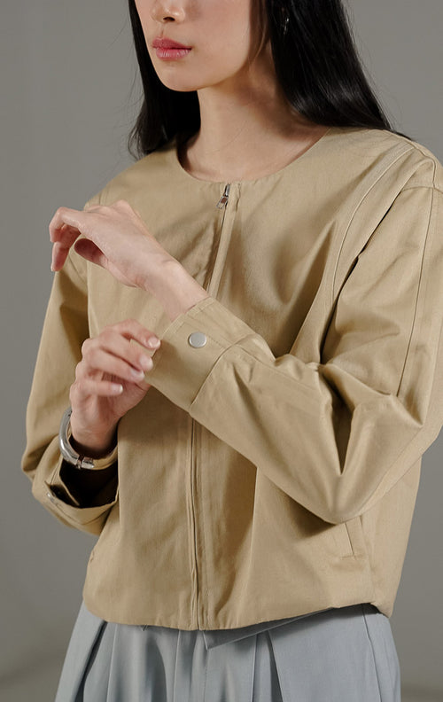  Othriel Jacket Khaki dari This Is April, jaket lengan panjang warna khaki dengan resleting depan, dua saku samping, dan kancing aktif pada bagian lengan.