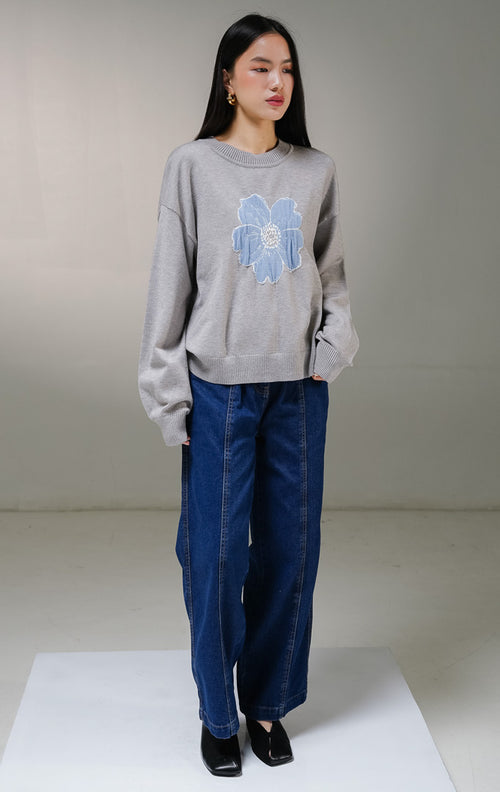 Atasan sweater rajut lengan panjang wanita This Is April Samantha Sweater warna abu-abu, model kerah bulat dengan detail motif grafis bunga besar warna biru di bagian tengah depan. 