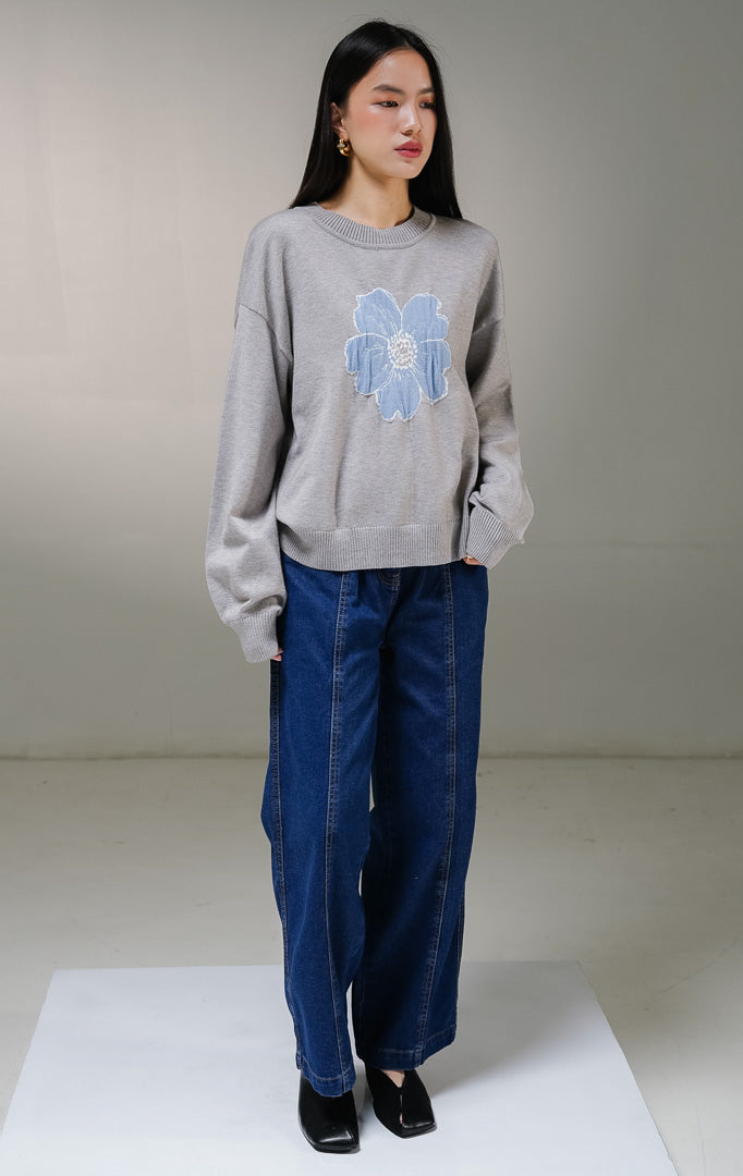 Atasan sweater rajut lengan panjang wanita This Is April Samantha Sweater warna abu-abu, model kerah bulat dengan detail motif grafis bunga besar warna biru di bagian tengah depan. 