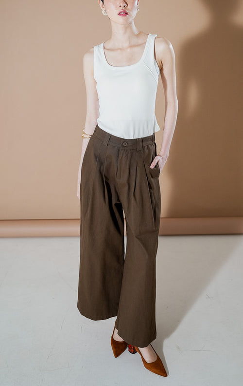 Yuriku Pants Dark Brown dari This Is April, celana panjang kulot wide-leg wanita warna cokelat tua dengan detail lipit depan (pleated) dan bahan katun terstruktur.