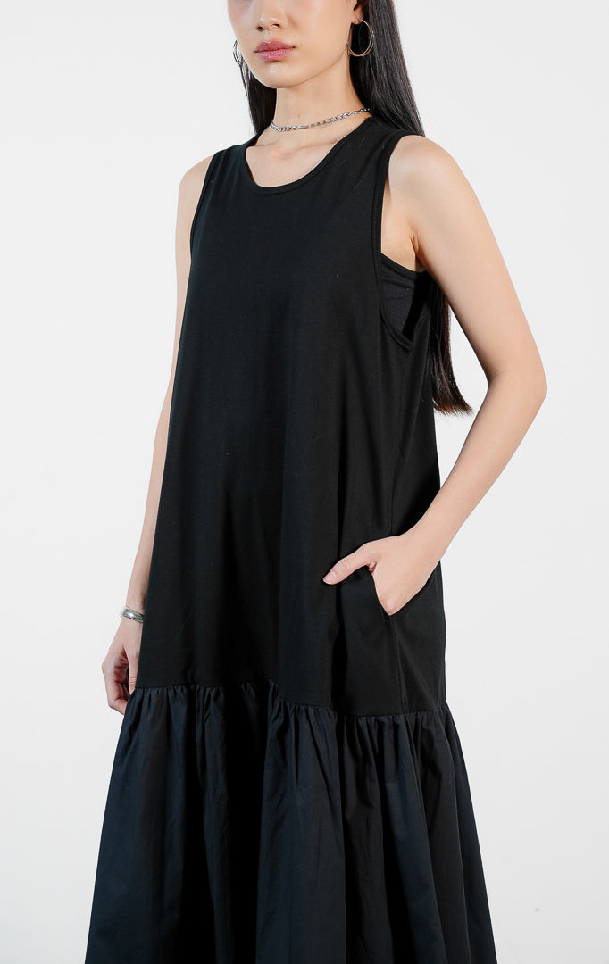 Pakaian wanita model terusan dress panjang tanpa lengan bahan katun warna hitam dengan detail rok kerut bertingkat (sleeveless flounce detail cotton dress) Alyona Dress untuk gaya kasual chic dan anggun.