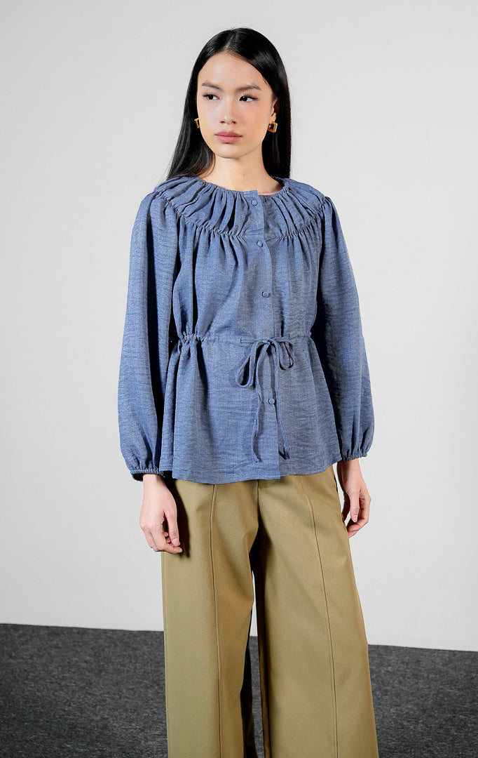 Pakaian wanita model blouse lengan panjang berkerut dengan detail tali serut pinggang dan kerah bahu terbuka (off-the-shoulder yoke blouse) warna navy Avelyn Top untuk gaya kasual chic.