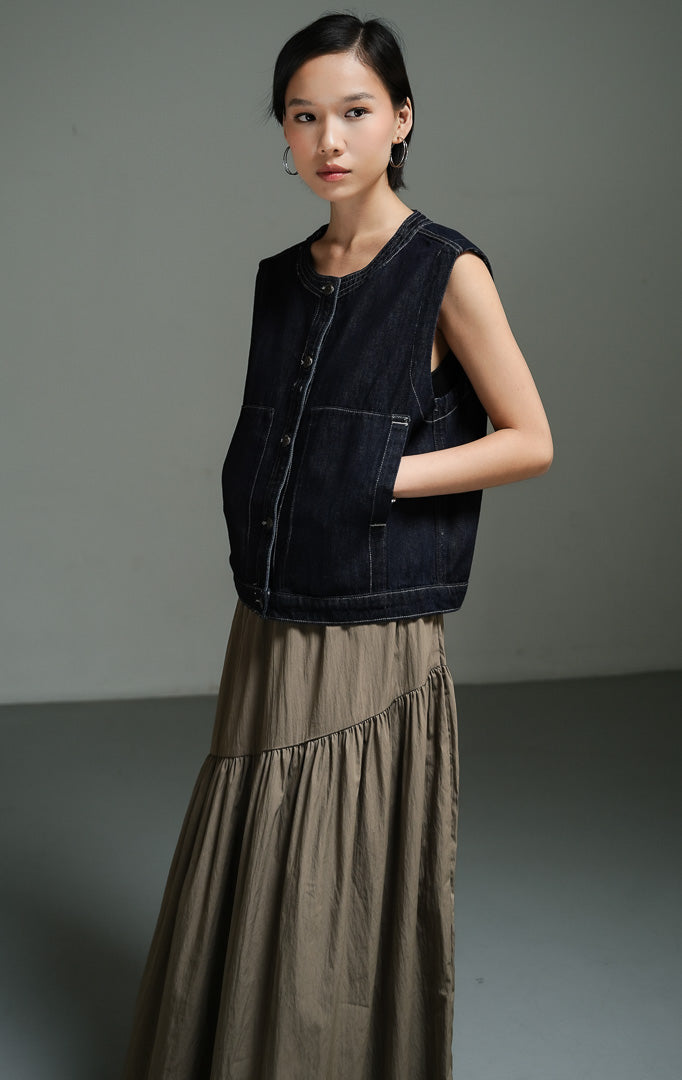 Atasan wanita model vest denim tanpa lengan warna indigo dengan detail saku tempel fungsional (indigo utility patch pocket denim vest) Caroline Vest untuk gaya lapisan kasual yang modern.