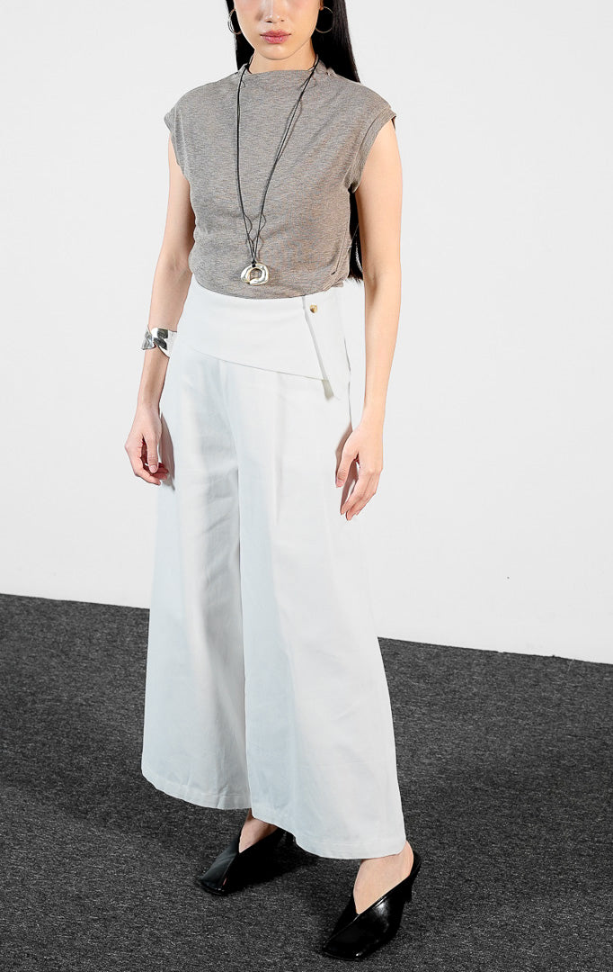 Bawahan wanita model celana panjang katun potongan lebar (white wide-leg pants) Christa Pants dengan detail pinggang lipat (fold-over waistband) yang struktural dan elegan.