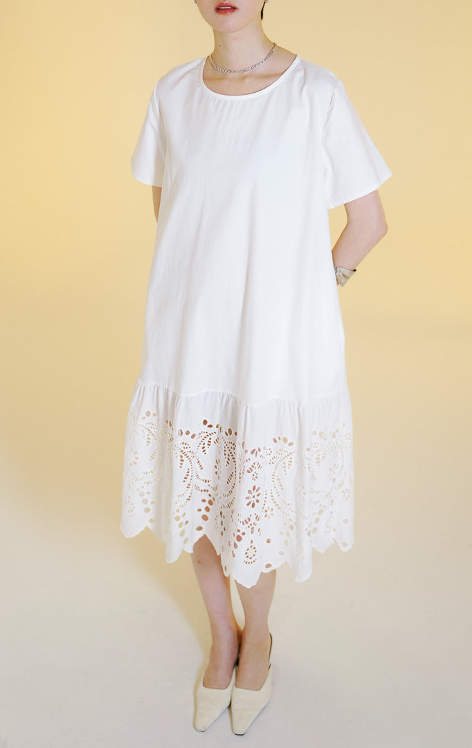 Pakaian wanita model gaun midi lengan pendek dengan detail bordir lubang bunga di bagian bawah (floral eyelet embroidered midi dress) warna putih Corrine Dress untuk gaya kasual anggun.