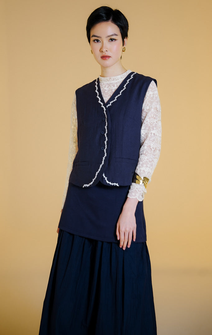 Pakaian rompi wanita tanpa lengan kerah V kancing depan bahan katun berfuring dengan hiasan renda gelombang dan manik-manik (ric-rac trim beaded cotton vest) warna navy Delilah Vest untuk gaya kantor dan kasual anggun. 
