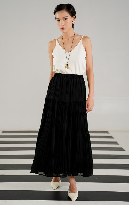 Rok panjang (maxi skirt) wanita warna hitam (black) dengan detail lipit (pleated), potongan bersusun atau berundak (tiered), dan karet pinggang elastis dari This Is April. 
